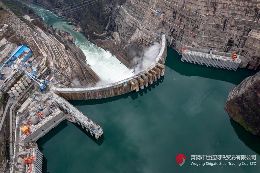 10月24日下午，白鶴灘水電站右岸地下廠房最后一倉封頂混凝土澆筑完成，標志著世界在建最大水電站地下廠房全線封頂。在該工程建設中，河鋼集團舞鋼公司累計生產(chǎn)供應Q500、Q345C/B、SX780等數(shù)個新品種鋼板4500噸，主要用于水電站水輪機座環(huán)、發(fā)電機頂蓋、控制環(huán)、壓力鋼管制造，大大加速了大型發(fā)電機組用鋼國產(chǎn)化進程。    據(jù)介紹，白鶴灘水電站位于四川省涼山州和云南省昭通市交界處，是世界在建規(guī)模最大的水電工程，裝機總容量1600萬千瓦，其左右岸地下廠房內(nèi)分別布置8臺具有完全自主知識產(chǎn)權的單機容量達100萬千瓦的水輪發(fā)電機組，單機容量位居世界第一。10月24日下午，白鶴灘水電站成功蓄水至825米高程，首次達到正常水位，大壩將接受高水位全面檢驗。    該工程的規(guī)模天然決定了其施工難度極高，復雜的地形地質(zhì)條件和技術指標等因素也給施工帶來了巨大挑戰(zhàn)。因此在電站建設材料及關鍵部位用鋼的選擇上，客戶慎之又慎，對焊接性能、韌性、強度等均有著極為嚴苛的技術要求。舞鋼公司憑借強大的質(zhì)量品牌優(yōu)勢和雄厚的技術實力成功中標——數(shù)百噸“舞鋼牌”高技術含量的大厚度高級別水電鋼板用于制造世界單機容量最大的巨型水輪發(fā)電機組的座環(huán)。    隨后，舞鋼公司為白鶴灘水電站定制研發(fā)265mm厚的SXQ500D-Z35鋼板，并進一步制作加工件。公司科技部高強鋼研究所針對該鋼的生產(chǎn)重點和難點，提前制定措施，并在冶煉、制坯等關鍵環(huán)節(jié)派人進行跟蹤、協(xié)調(diào)。在科技、設備、生產(chǎn)人員的共同努力下，該批鋼板最終順利生產(chǎn)完畢。鋼板及試樣經(jīng)公司、客戶和第三方檢驗機構檢驗合格后，在三和盛機建公司完成切割深加工。    交付客戶后，該鋼憑著焊接性能好、力學結構良好、低溫沖擊韌性強等優(yōu)點，承受住了巨大的水壓力和沖擊負荷，再次贏得設備制造方的高度評價。（舞鋼市委宣傳部 楊德坤 張培軍）